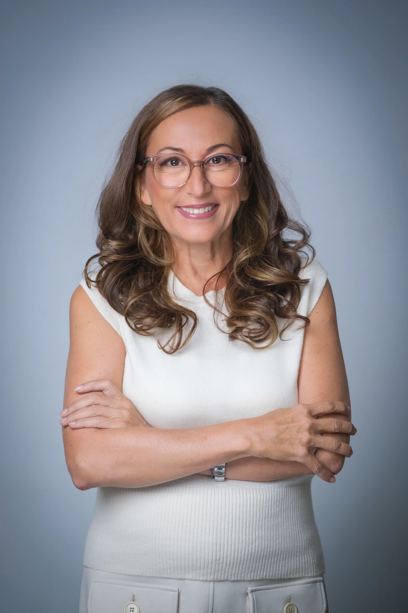 Dr. Isabella Wilden in a white top, arms crossed, smiling
