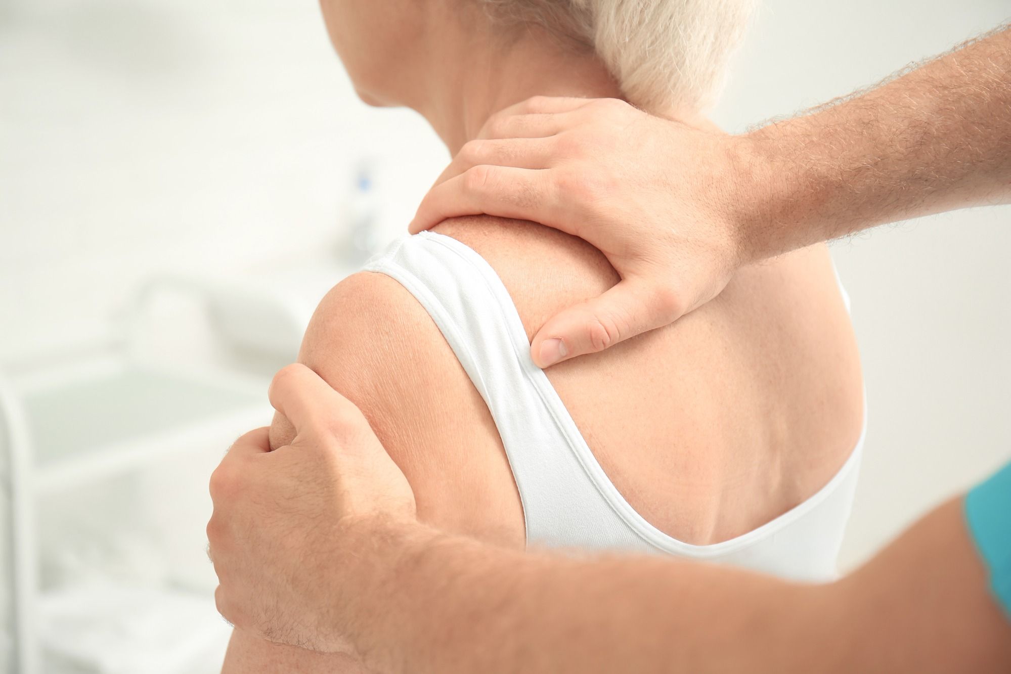 Seniorin erhält eine Massage von Physiotherapeuten wegen Rückschmerzen