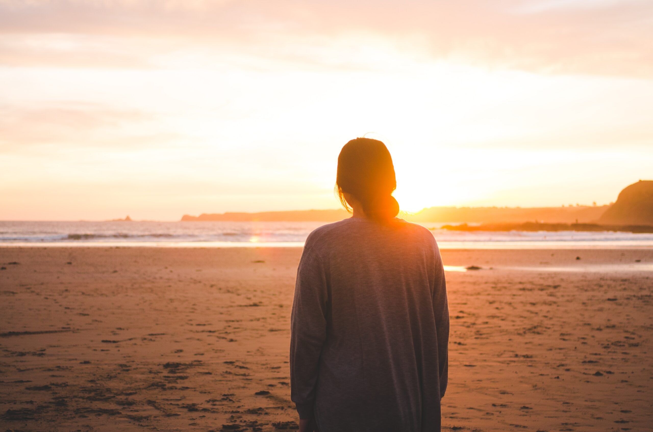 Frau in den Wechseljahren vor einem Sonnenuntergang